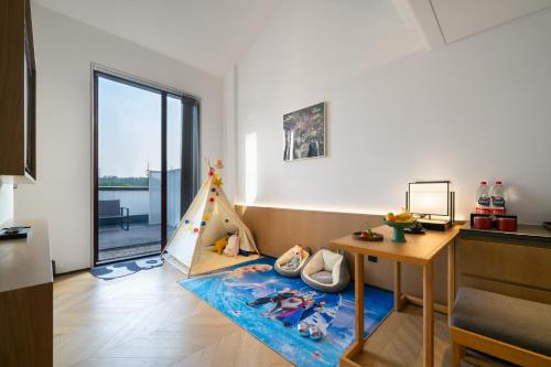 a childs room with a christmas tree and a table at POKKEI Hotel Shaoxing in Shaoxing