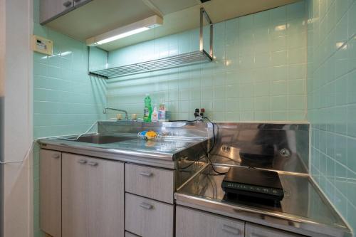 Il comprend une cuisine équipée d'un évier et d'une cuisinière. four supérieur dans l'établissement REBANGA Juso Apartment, à Osaka
