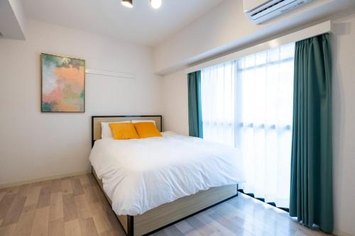 a bedroom with a bed and a large window at REBANGA Juso Apartment in Osaka