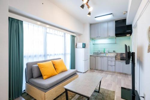 a living room with a couch and a table at REBANGA Juso Apartment in Osaka