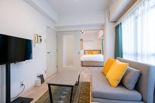 a living room with a couch and a bed at REBANGA Juso Apartment in Osaka