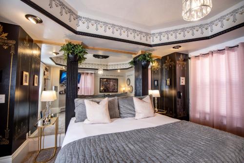 a bedroom with a large bed and a chandelier at The Anniversary Inn - Logan in Logan