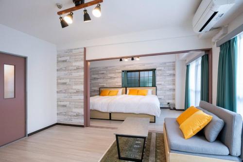 - une chambre avec un lit et un canapé dans l'établissement REBANGA Juso Apartment, à Osaka
