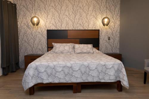 1 dormitorio con 1 cama con edredón blanco en Casa Mia Suite San Juan de los Lagos en San Juan de los Lagos