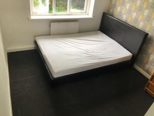 Comfort zone accommodation near care home في Coseley: سرير في غرفة صغيرة مع نافذة