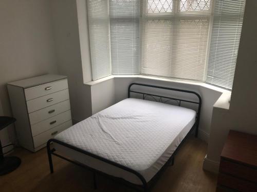 a small bedroom with a bed and a window at Comfort zone accommodation near care home in Coseley