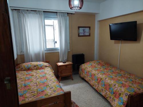 1 dormitorio con 2 camas y TV de pantalla plana en Luminoso depto frente al mar y casino en Mar del Plata