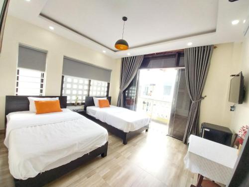 a hotel room with two beds and a tv at Giao Hòa Homestay Hội An in Hoi An