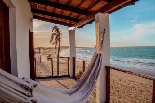 a hammock in a room with a view of the beach at Chalé Galo Preto in Galinhos