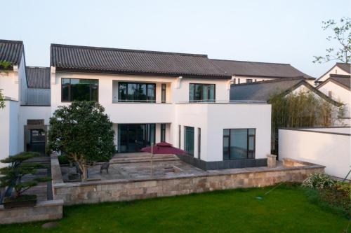 a large white house with a yard at POKKEI Hotel Shaoxing in Shaoxing