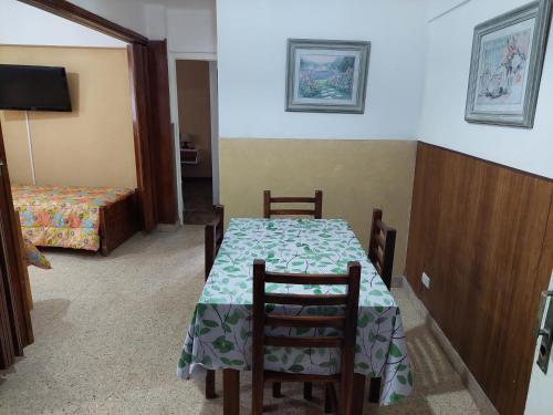 una habitación con mesa y sillas y un dormitorio en Luminoso depto frente al mar y casino en Mar del Plata
