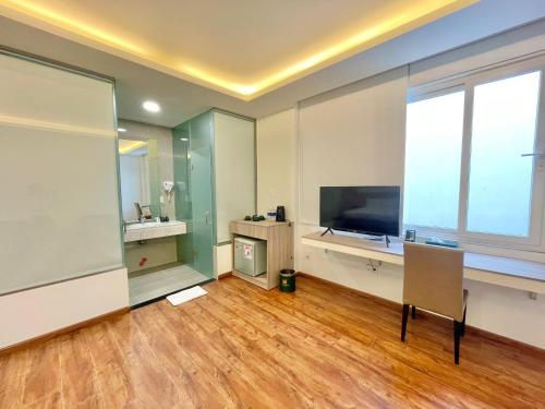 a living room with a television and a large window at The Mansion Hotel Bien Hoa in Bien Hoa