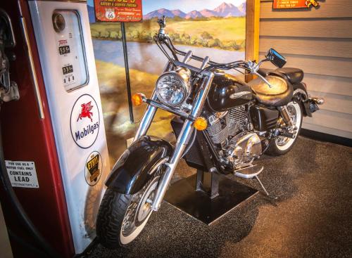a motorcycle is parked next to a gas pump at The Anniversary Inn - Logan in Logan