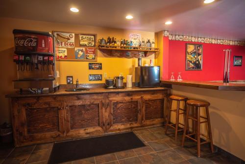 a bar with a wooden counter in a room at The Anniversary Inn - Logan in Logan