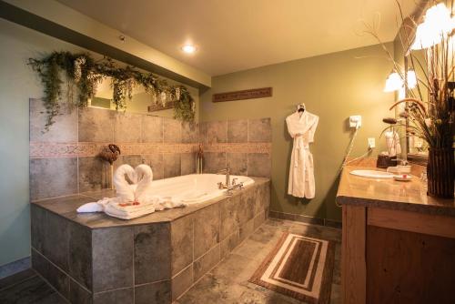 a bathroom with a tub and a sink at The Anniversary Inn - Logan in Logan
