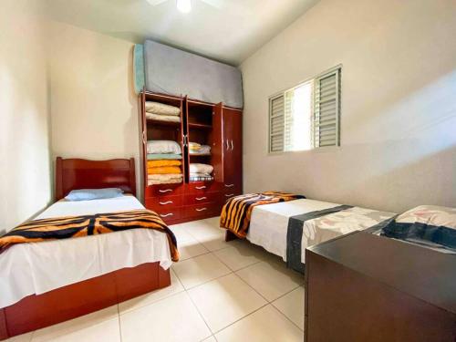 a bedroom with two beds and a counter in it at Casa entre Cabo Frio e Arraial do Cabo in Cabo Frio
