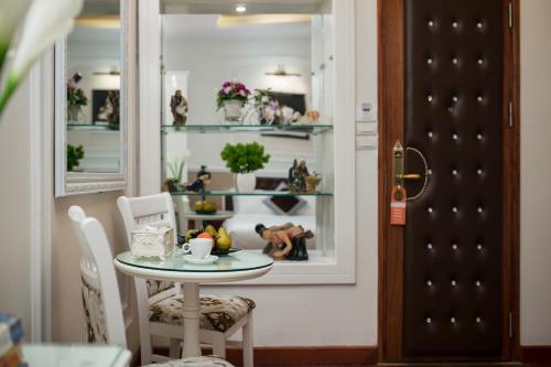 a table and chairs in a room with a window at TrangTrang Premium Hotel & Sky Bar in Hanoi