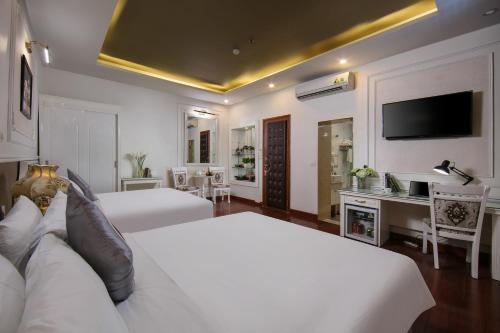 a hotel room with two beds and a television at TrangTrang Premium Hotel & Sky Bar in Hanoi
