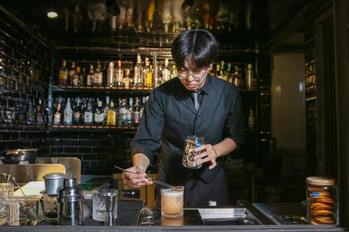 a man standing behind a bar preparing a drink at TrangTrang Premium Hotel & Sky Bar in Hanoi