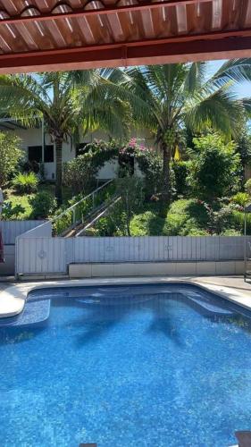 a large swimming pool in a yard with palm trees at Villa Garita Inn in La Garita