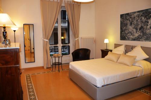 ein Schlafzimmer mit einem Bett, einem Stuhl und einem Fenster in der Unterkunft Residenza Santa Lucia in Neapel