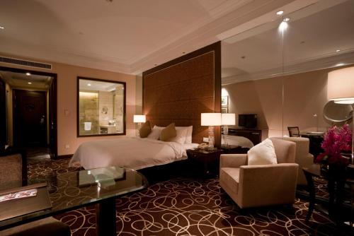 a hotel room with a bed and a living room at Howard Johnson Tongfang Plaza Zhuji in Zhuji