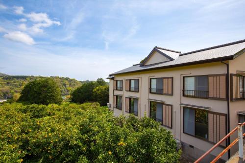 an apartment building with a view of a garden at 森の風 in Higashiizu