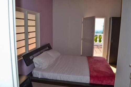 a bedroom with a white bed and a window at Finca con hermosa vista, billar pool, piscina, atardeceres in Pereira