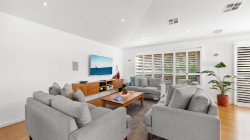 a living room with two couches and a tv at Marley's Retreat - Patonga Beach in Patonga Beach