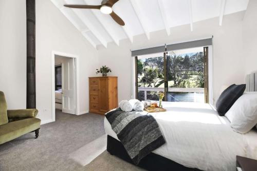 Un dormitorio con una cama grande y una ventana en Comrie, Bundanoon, en Bundanoon