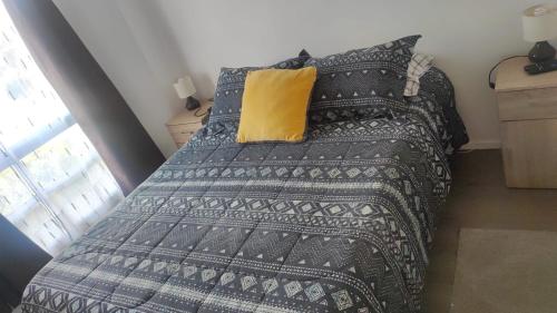 una camera con letto e cuscino giallo di Departamento La Serena, amoblado, 2 habitaciones, a una cuadra de la playa a La Serena