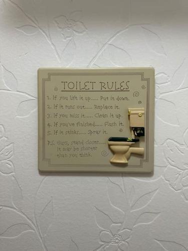 カーライルにあるCarlisle The Cathedral City And Gateway In Cumbriaのトイレのルールが書かれた壁にトイレットペーパーディスペンサー