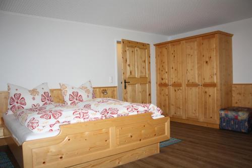 1 dormitorio con cama de madera y armarios de madera en Haus Bachmann, en Assling