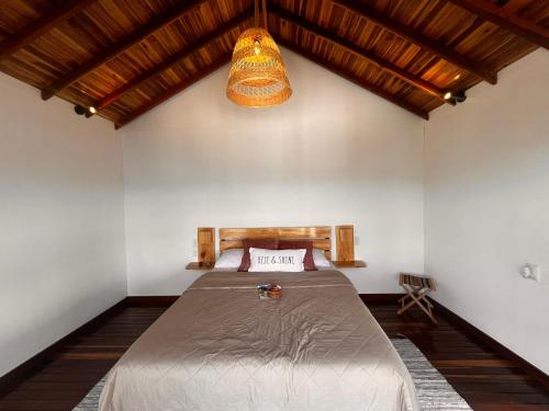 1 dormitorio con cama y luz colgante en Chalets La Zima - Jaya, en Curití
