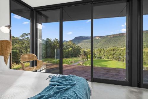 a bedroom with a bed and a large window at Far Niente, Kangaroo Valley in Upper Kangaroo River