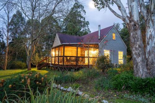 a house with a wrap around porch in the woods at KV Cottage, Kangaroo Valley in Kangaroo Valley