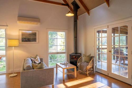 a living room with a couch and a stove at KV Cottage, Kangaroo Valley in Kangaroo Valley