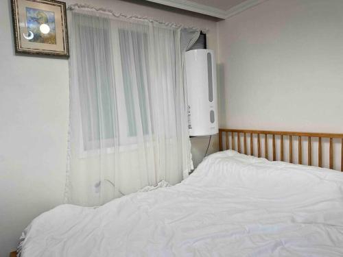 ein Schlafzimmer mit einem weißen Bett und einem Fenster in der Unterkunft Gurosien 3 bedroom house in Seoul