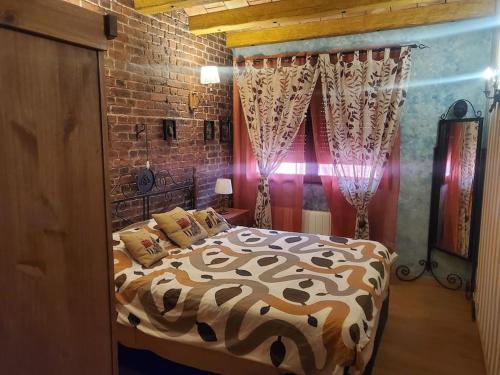 a bedroom with a bed and a brick wall at Chalet entero en La Rioja in Briones