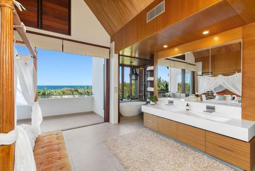 a bathroom with two sinks and a large window at Kingscliff Balinese Beachfront Retreat in Kingscliff