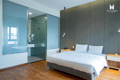 1 dormitorio con 1 cama grande y ducha de cristal en The Mansion Hotel Bien Hoa en Bien Hoa