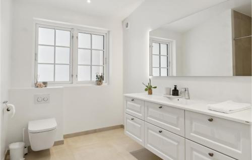 Baño blanco con aseo y lavamanos en Gorgeous Home In Liseleje With Wifi en Liseleje