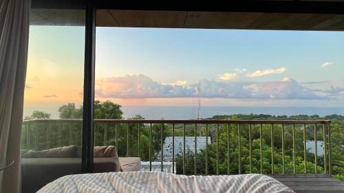 a bedroom with a view of the ocean from a balcony at Salty Breeze Bali in Ungasan