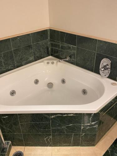 a bath tub in a bathroom with green tile at Oaks resort in Gold Coast