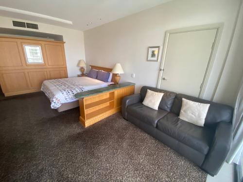 una camera d'albergo con divano e letto di Oaks resort a Gold Coast