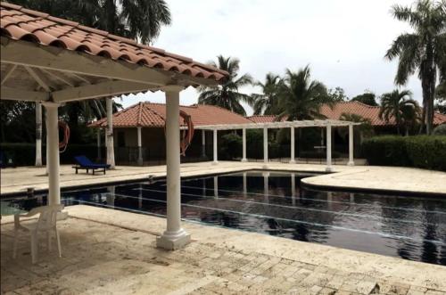 una piscina con un pabellón junto a una casa en Acojedora villa familiar en cartagena, a 20 minutos del aeropuerto, en Cartagena de Indias