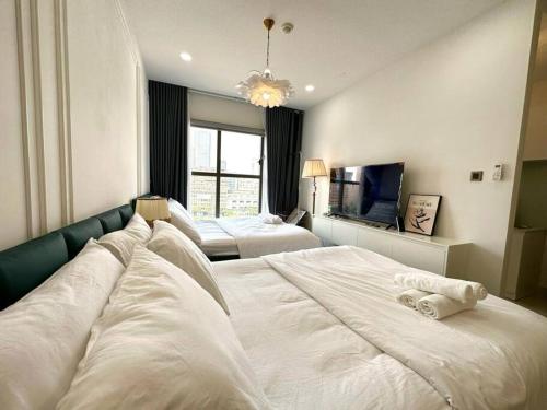 a bedroom with two white beds and a chandelier at New Saigon Royal Luxury Condo 4pax Best City View in Ho Chi Minh City