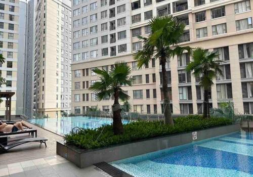 a woman sitting on a bench next to a large building at New Saigon Royal Luxury Condo 4pax Best City View in Ho Chi Minh City