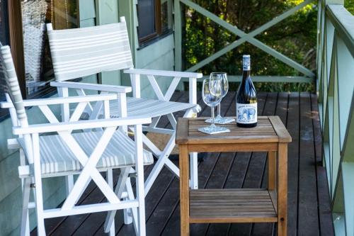 a bottle of wine sitting on a table next to two chairs at Villa 27 Kangaroo Valley Golf Course, Kangaroo Valley in Kangaroo Valley