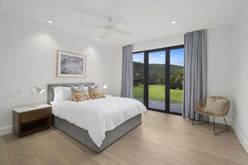 a bedroom with a bed and a large window at Serendipity, Kangaroo Valley in Barrengarry